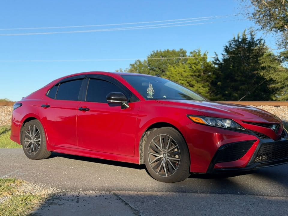 A red Toyota Camry with tinted windows
